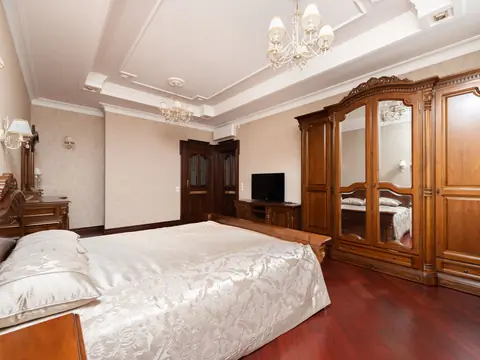 A bedroom with a large carved timber wardrobe and a double bed