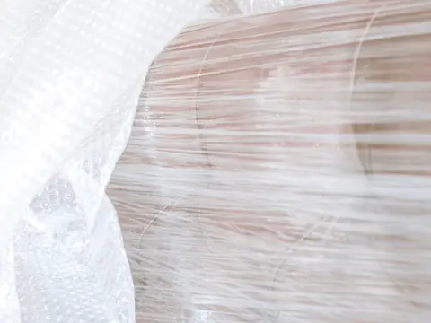 A piece of furniture wrapped in bubble wrap and stretch film