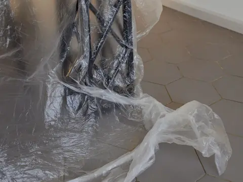 Plastic sheeting wrapped round the metal leg of a table